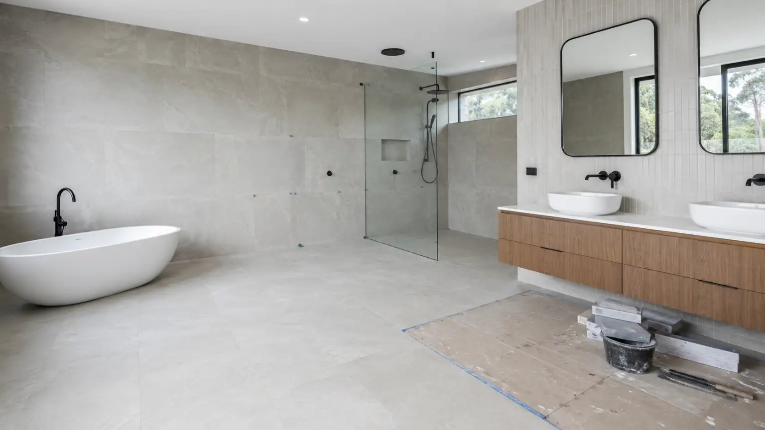 Modern bathroom during renovation with a freestanding bathtub, walk-in shower, timber double vanity and matte black fixtures